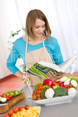 Cooking - Woman reading cookbook in kitchen