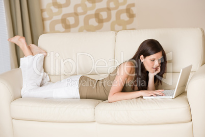 Young woman with laptop on sofa home