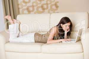 Young woman with laptop on sofa home