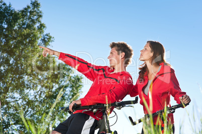 Young couple with mountine bike in spring nature