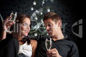 Young extravagant man and woman with champagne on Christmas