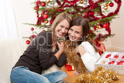 Two cheerful women with Christmas chains and balls