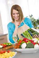 Cooking - Smiling woman holding cookbook, with vegetable and pas