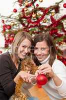 Two cheerful women with Christmas chains and balls