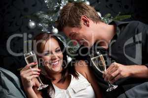 Young extravagant man and woman with champagne on Christmas