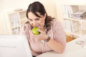 Young happy businesswoman holding apple at office