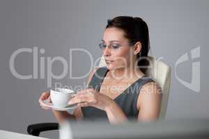 Successful business woman at office having coffee