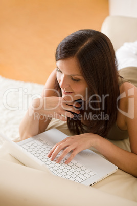 Young woman with laptop on sofa home