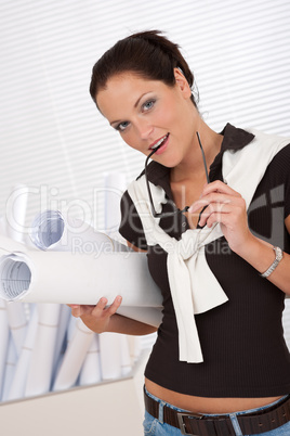 Smiling female architect holding plans and glasses