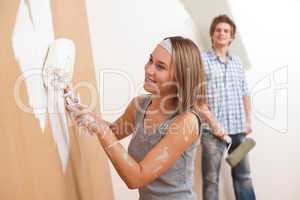 Home improvement: Young man and woman painting wall