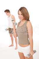 Fitness - Young couple training lifting weights on white