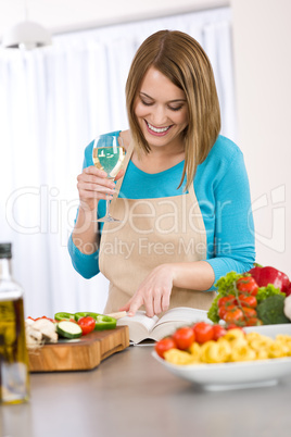 Cooking - Smiling woman reading recipe from cookbook