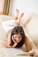 Young woman with laptop on sofa home