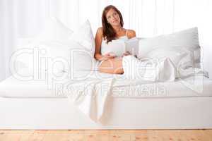 White lounge - Young woman sitting on white bed