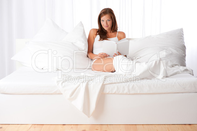 White lounge - Young woman sitting on white bed