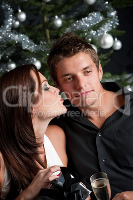 Young sexy couple in front of Christmas tree
