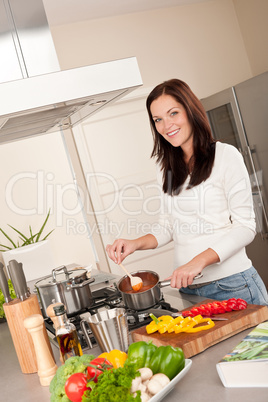 Young woman cooking tomato sauce in the kitchen