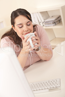 Happy businesswoman having coffee break at office