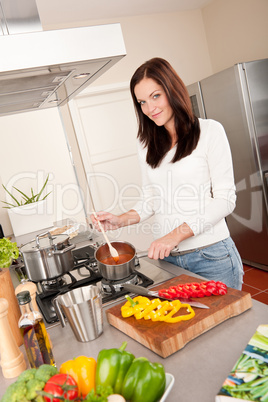 Young smiling woman cooking in the kitchen