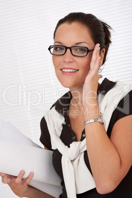 Smiling female architect holding plans and glasses