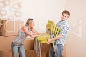 Moving house: Young couple with box and chair