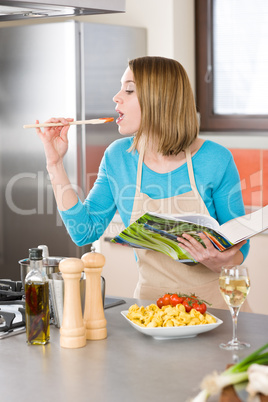 Cooking - Young woman tasting tomato sauce in kitchen