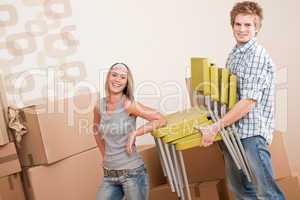Moving house: Young couple with box and chair