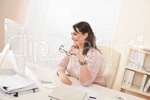 Smiling young businesswoman sitting at office