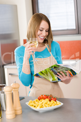 Cooking - Smiling woman reading recipe from cookbook