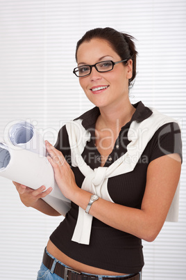 Smiling female architect with glasses holding plans