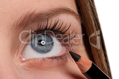 Blue eye, woman applying black make-up pencil