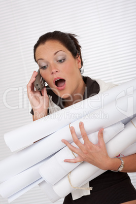 Young attractive female architect holding plans and telephone