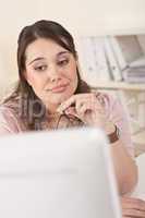 Young businesswoman watching computer screen at office