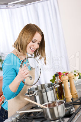 Cooking - Happy woman by stove in kitchen