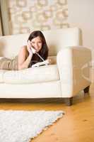 On the phone: young woman calling in lounge