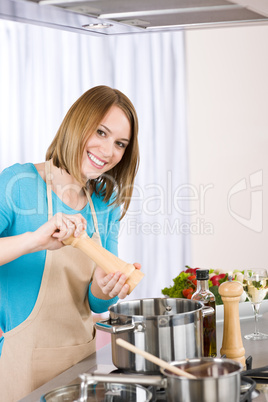 Cooking - Happy woman by stove in kitchen