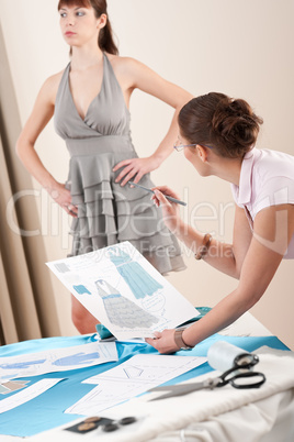 Model fitting by female fashion designer