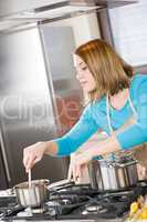 Cooking - Woman stir Italian tomato sauce in modern kitchen