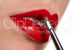 Woman applying glossy red lipstick on white background