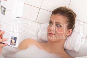 Body care series - Young woman reading magazine in the bathtub