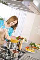 Cooking - Young woman with spaghetti on stove