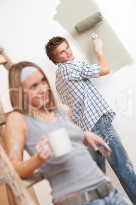 Home improvement: Young couple painting wall