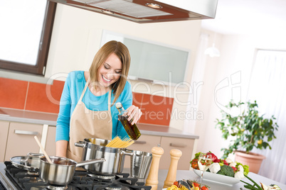 Cooking - Young woman with spaghetti on stove