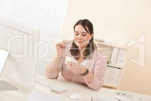 Young businesswoman eating yogurt at office