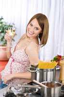 Smiling woman cooking spaghetti