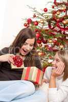 Two smiling women unpacking Christmas present