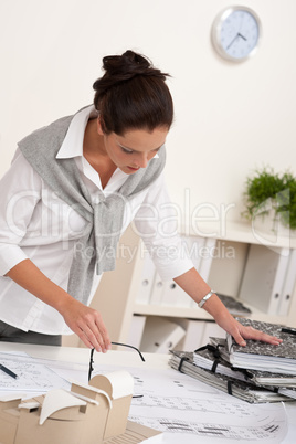 Smiling female architect working with plans