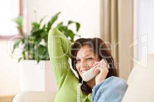On the phone home: Happy woman calling