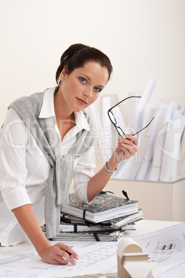 Smiling female architect with plans at the office