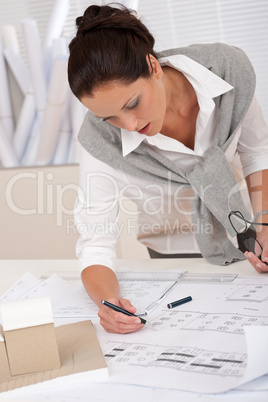 Female architect watching plans at the office